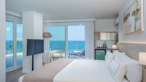 A hotel room with a large bed, a TV, a desk, and a view of the ocean. - Hotel Las Arenas, Affiliated by Meliá (Benalmádena)