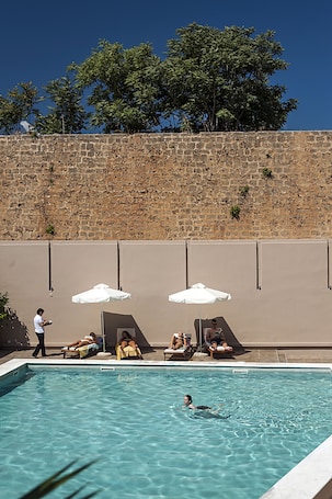 Una piscina al aire libre de temporada, sombrillas
