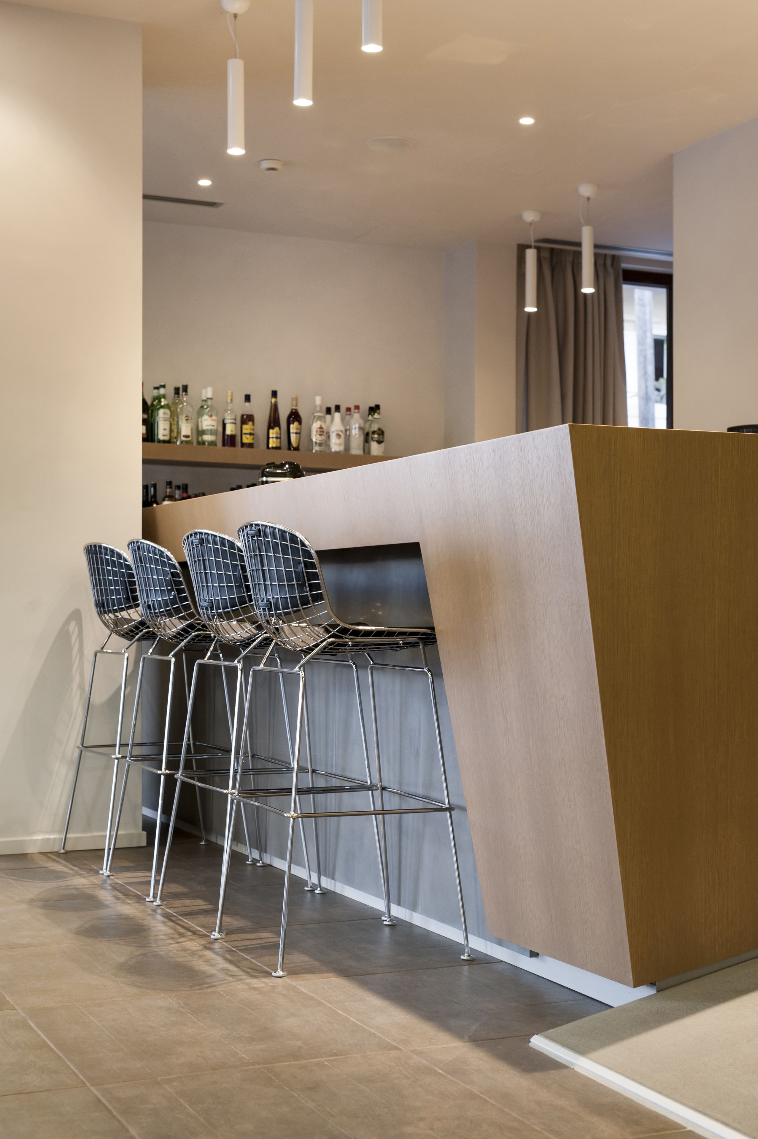 Eine moderne Küche mit Bar, Barhocker und einer Flaschenregal.
