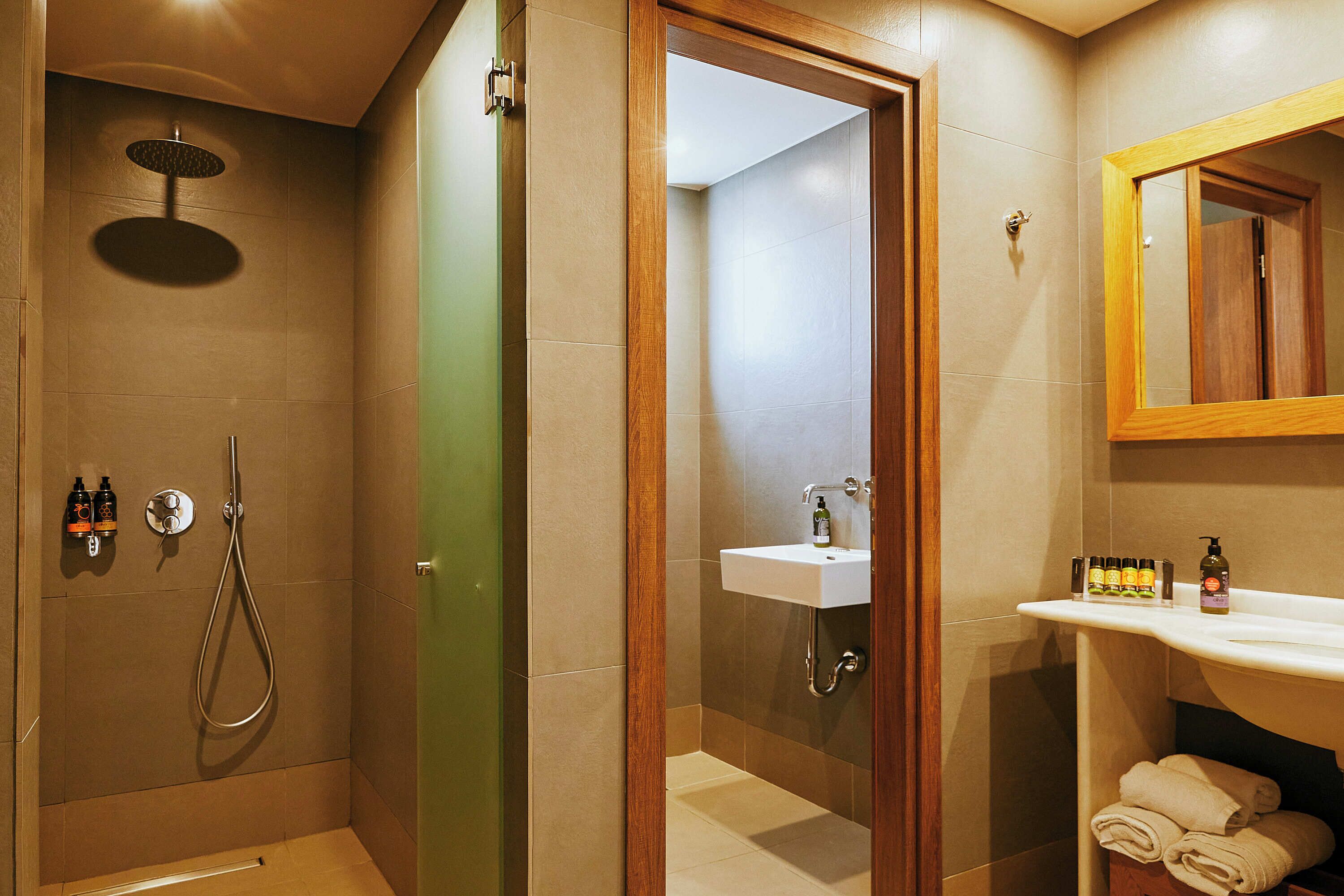 Ein Badezimmer mit Dusche, Waschbecken und Spiegel.