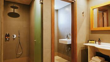 Ein Badezimmer mit Dusche, Waschbecken und Spiegel.