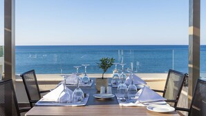 A table set for dining with a view of the ocean. - Giannoulis – Grand Bay Beach Resort - Adults Only (Platanias)
