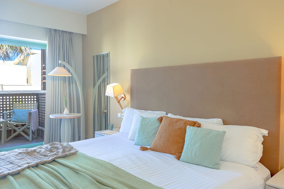 Ein Hotelzimmer mit einem Bett, einem Sessel, einem Tisch und einer Lampe.
