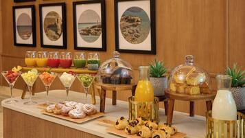 A breakfast buffet with various food items and drinks.
