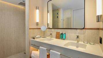 Un baño moderno con dos lavamanos, un espejo grande y un perchero para toallas.