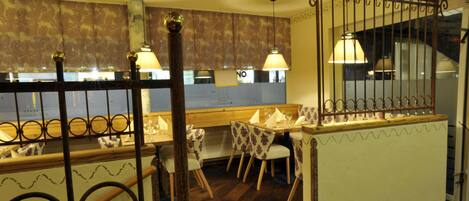 A restaurant interior with a wooden table labeled 'Renes Steakhouse', a bar area, and patterned chairs.