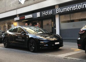 A black car with 'René Steakhouse' branding parked in front of a hotel named 'Hotel Blumenstein'. - Hotel Blumenstein (Frauenfeld)