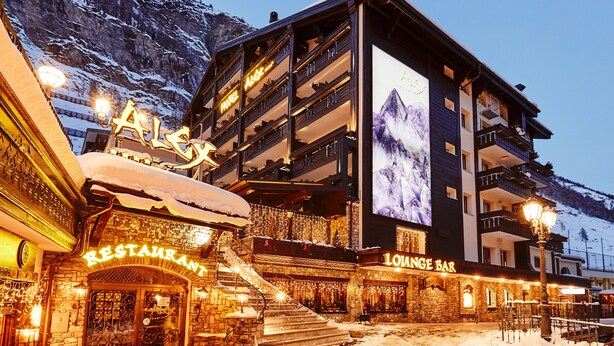 Un hotel con restaurante y bar salón, con vistas a la montaña y paisajes nevados.