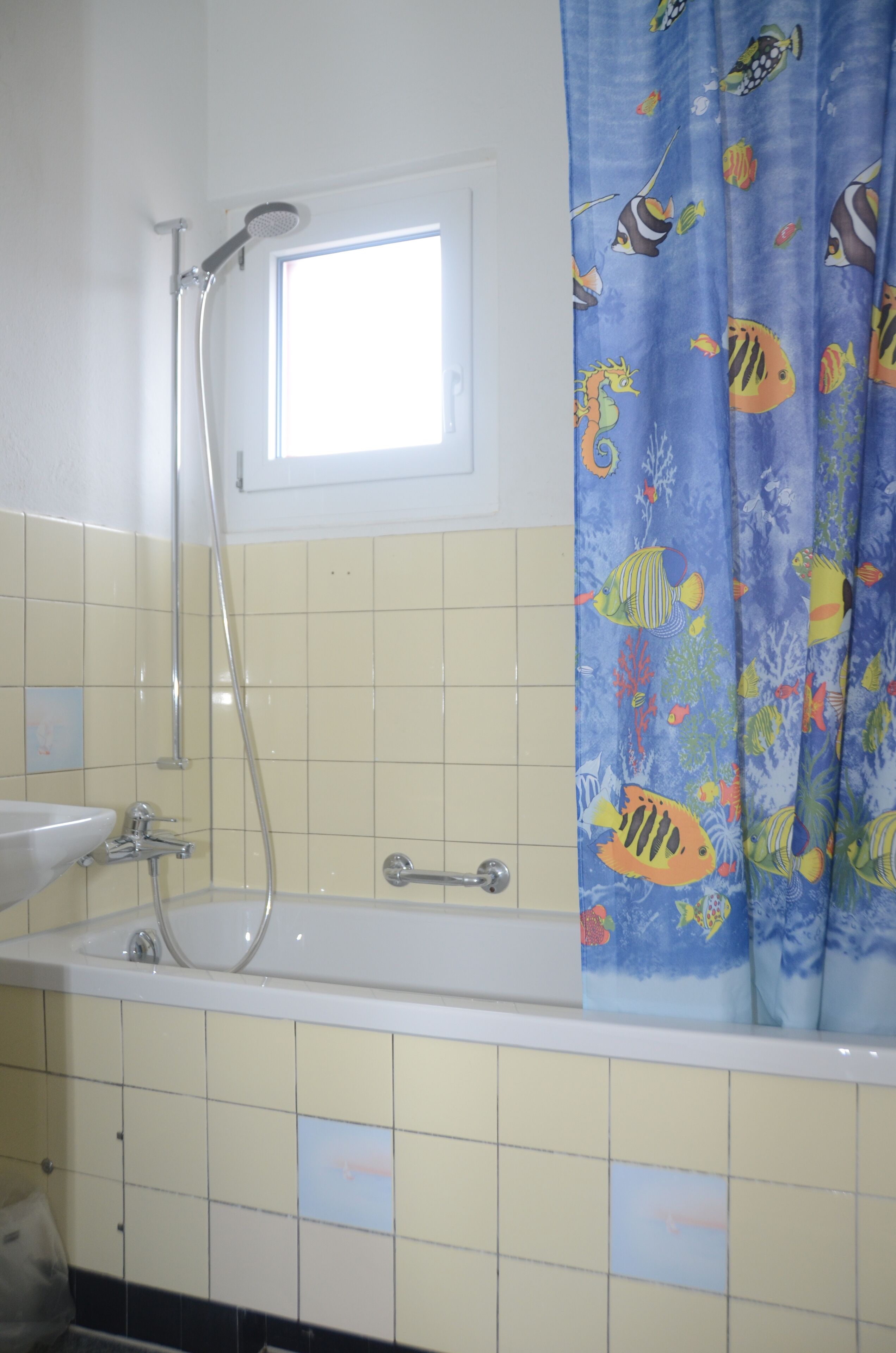A bathroom with a bathtub, a shower, and a window.