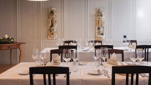 A dining table set for a meal with multiple chairs, glasses, and cutlery. - Bäre Madis (Madiswil)