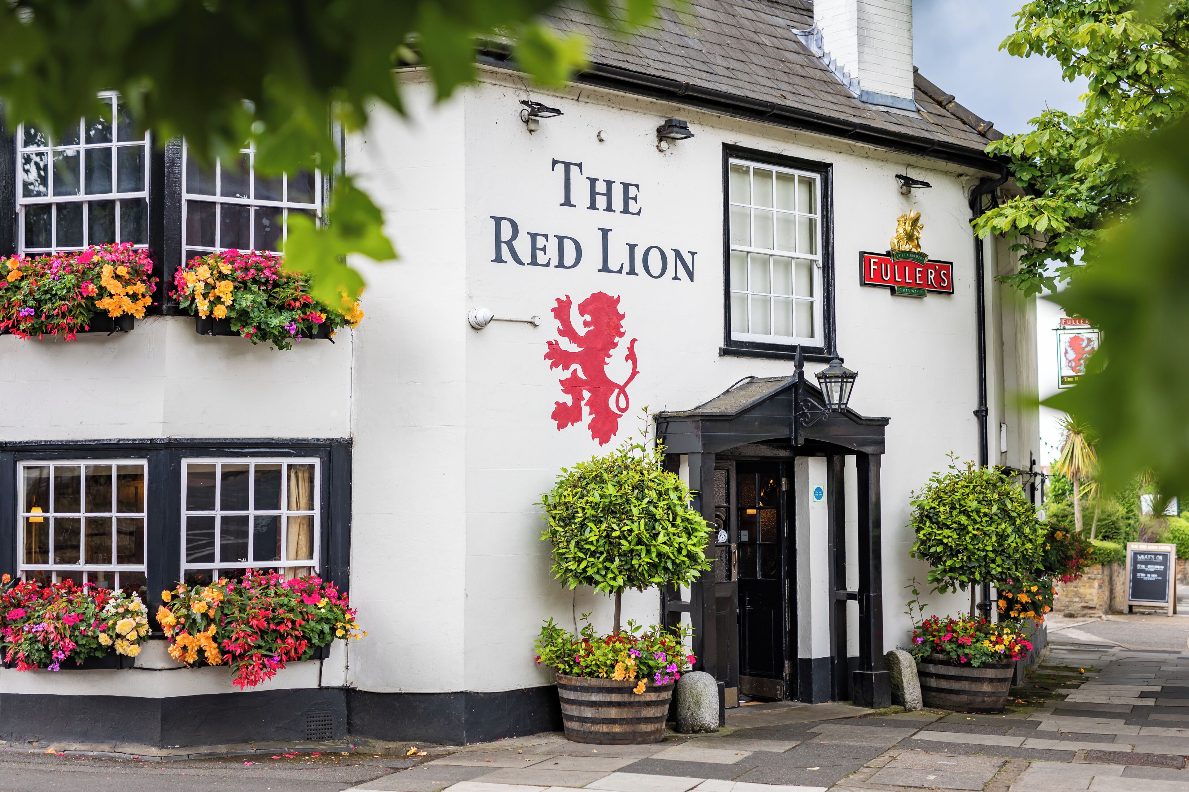 A building with a sign reading "The Red Lion" and "Fuller's" on the side.