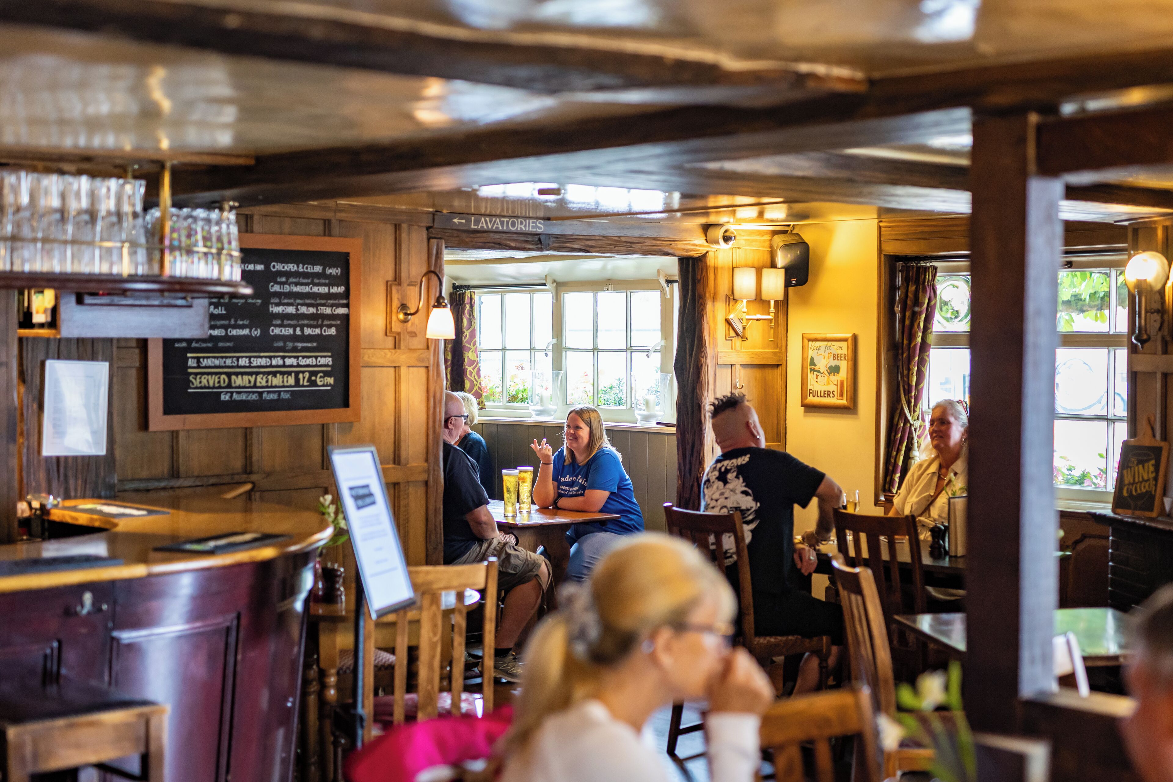 A restaurant interior with wooden decor, a bar area, and a menu board.