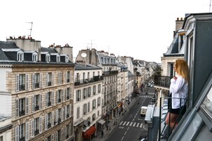 A view of a city street from a high vantage point, with buildings on either side and a clear sky.
