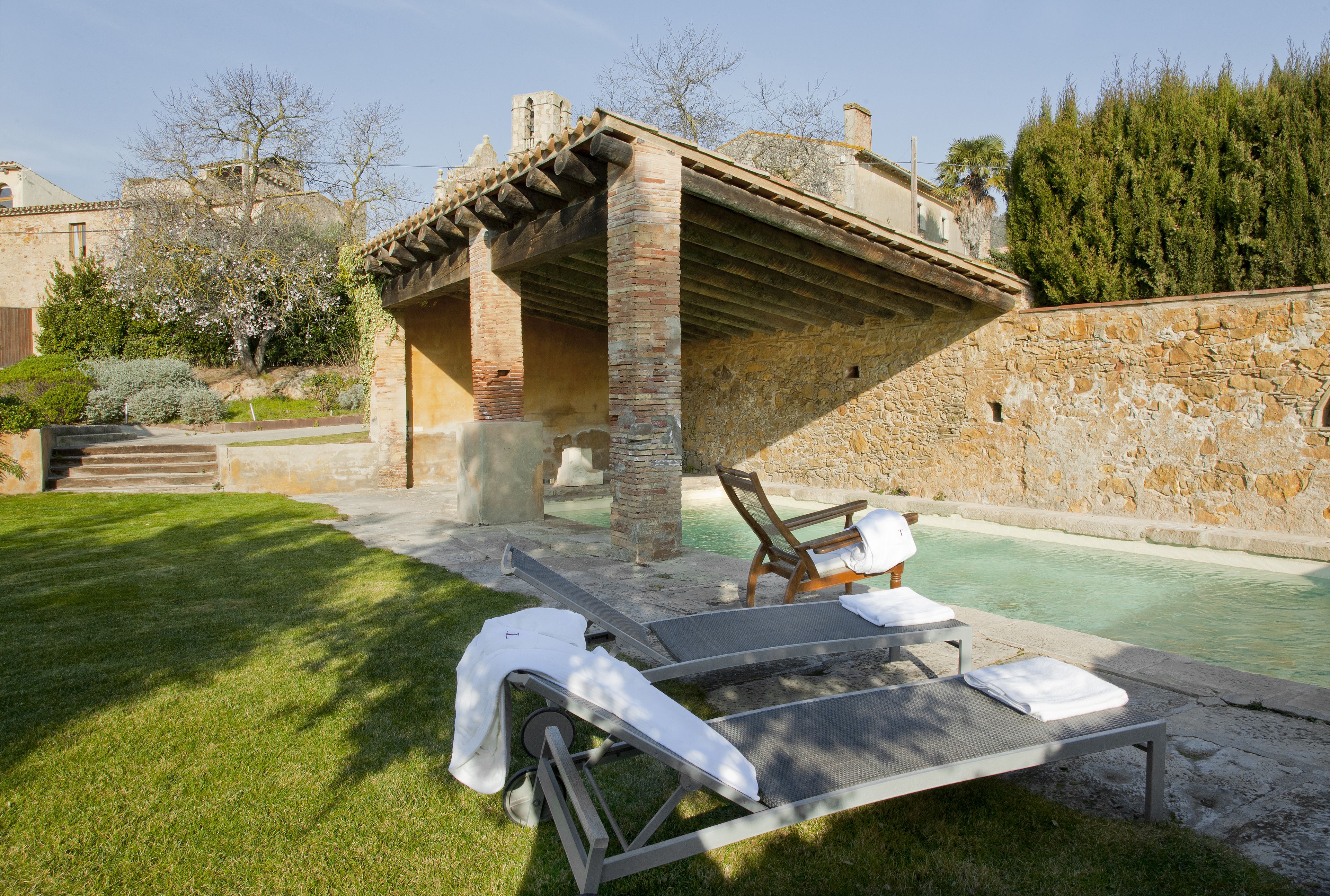 A poolside area with lounge chairs and a pergola structure.