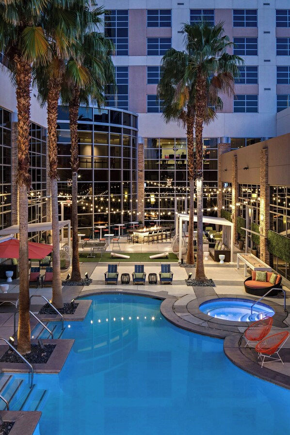 Una piscina al aire libre, sombrillas, sillones reclinables de piscina