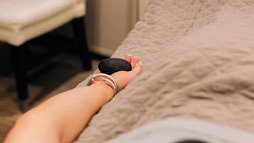 A person lying on a bed with a massage device on their back.