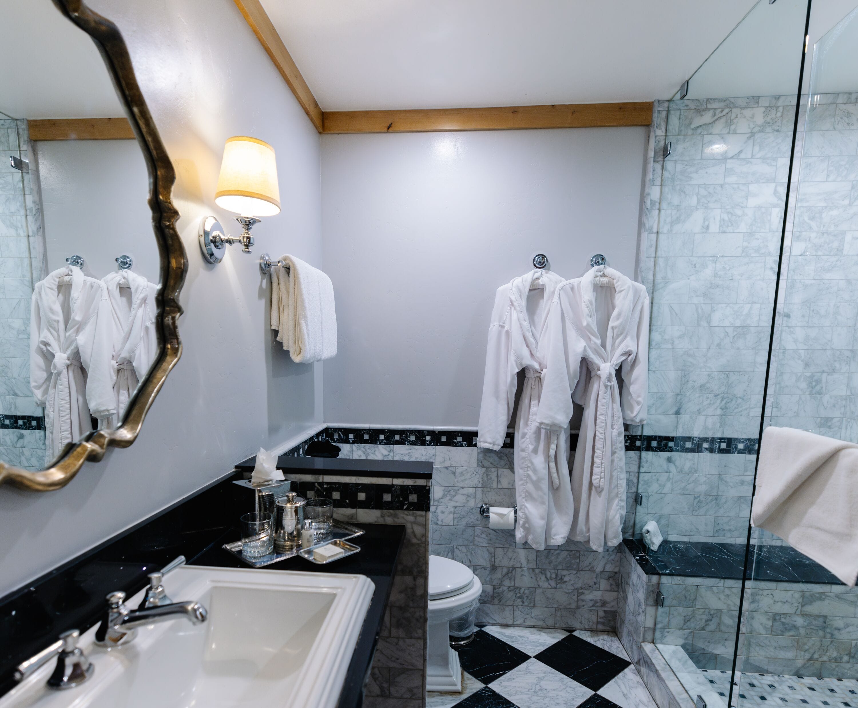 A modern bathroom with a large mirror, a sink, a toilet, and a shower area.