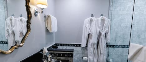 A modern bathroom with a large mirror, a sink, a toilet, and a shower area.
