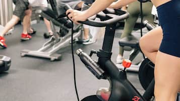 A gym with stationary bikes, treadmills, and a person using an exercise bike.