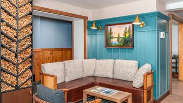 A corner seating area with a cushioned bench, a small table, and a wall-mounted painting.
