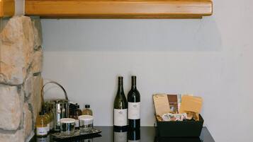 A kitchen counter with a wine bottle, a basket, and a framed picture.