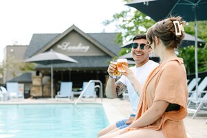 Escena junto a una piscina, con un edificio en el fondo que dice 'The Landing'.