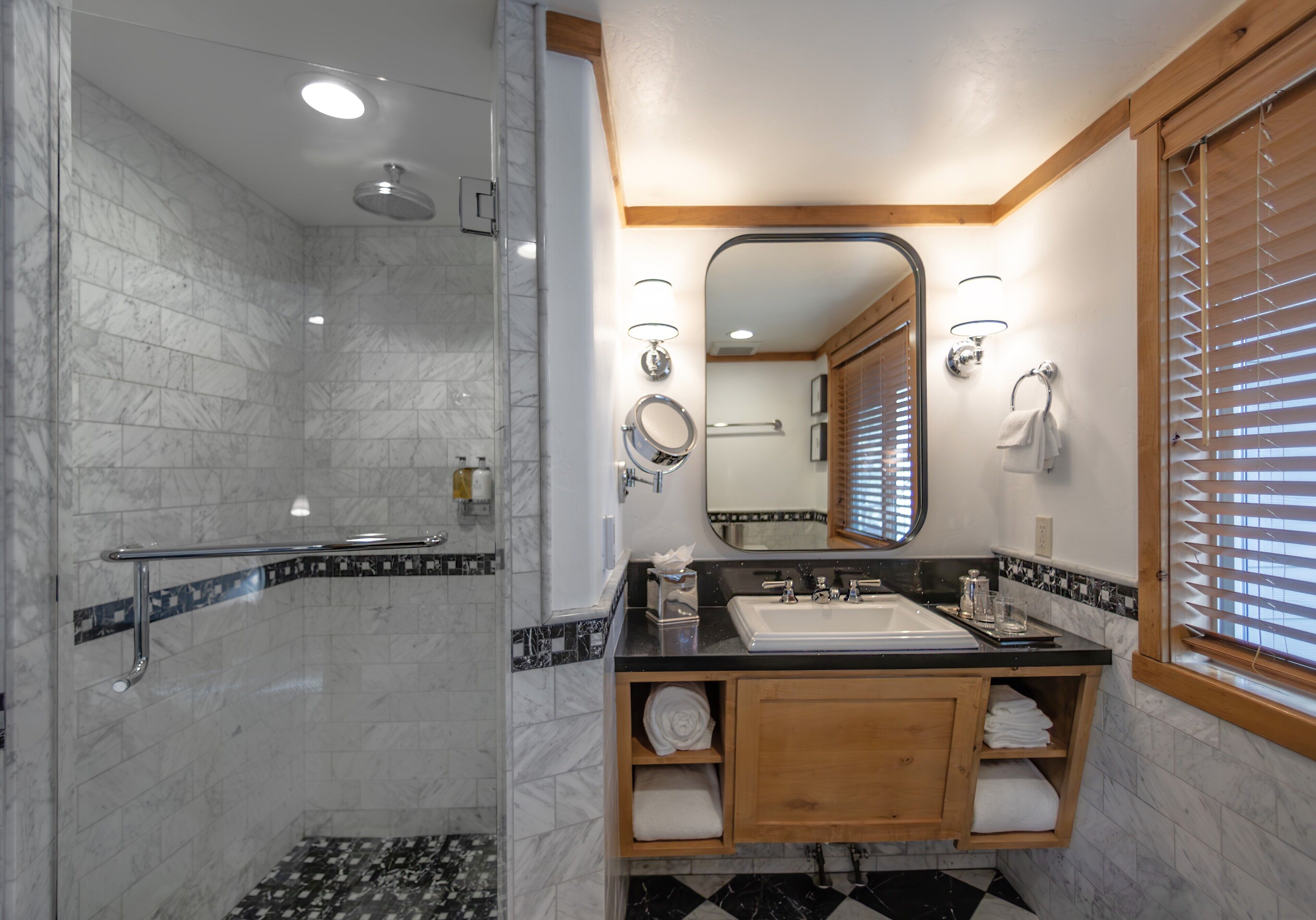 Une salle de bain avec une douche, un lavabo et un miroir.