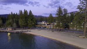 A lakeside property with a dock, beach, and forested area. - The Landing Resort & Spa (South Lake Tahoe)