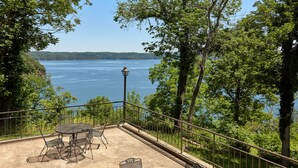 Une terrasse avec une table et des chaises donnant sur un lac.