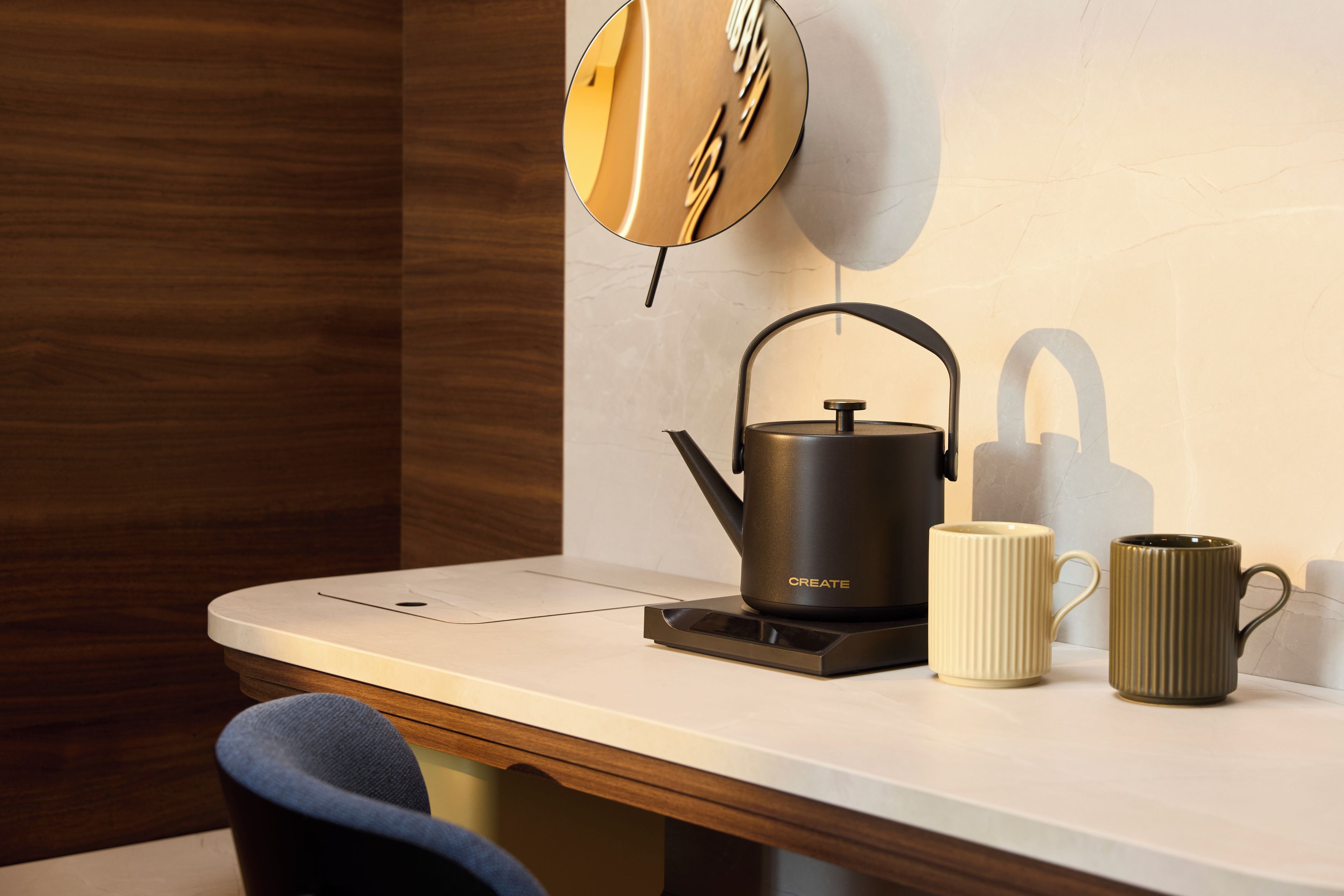 Cocina moderna con tetera, taza y bloque de cuchillos sobre la encimera.