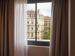 A window with curtains, a view of a building with classical architecture. - You Hotel de France Valence - Handwritten Collection. T3 26 (Valence)