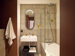 A bathroom with a sink, mirror, towel rack, and shower.