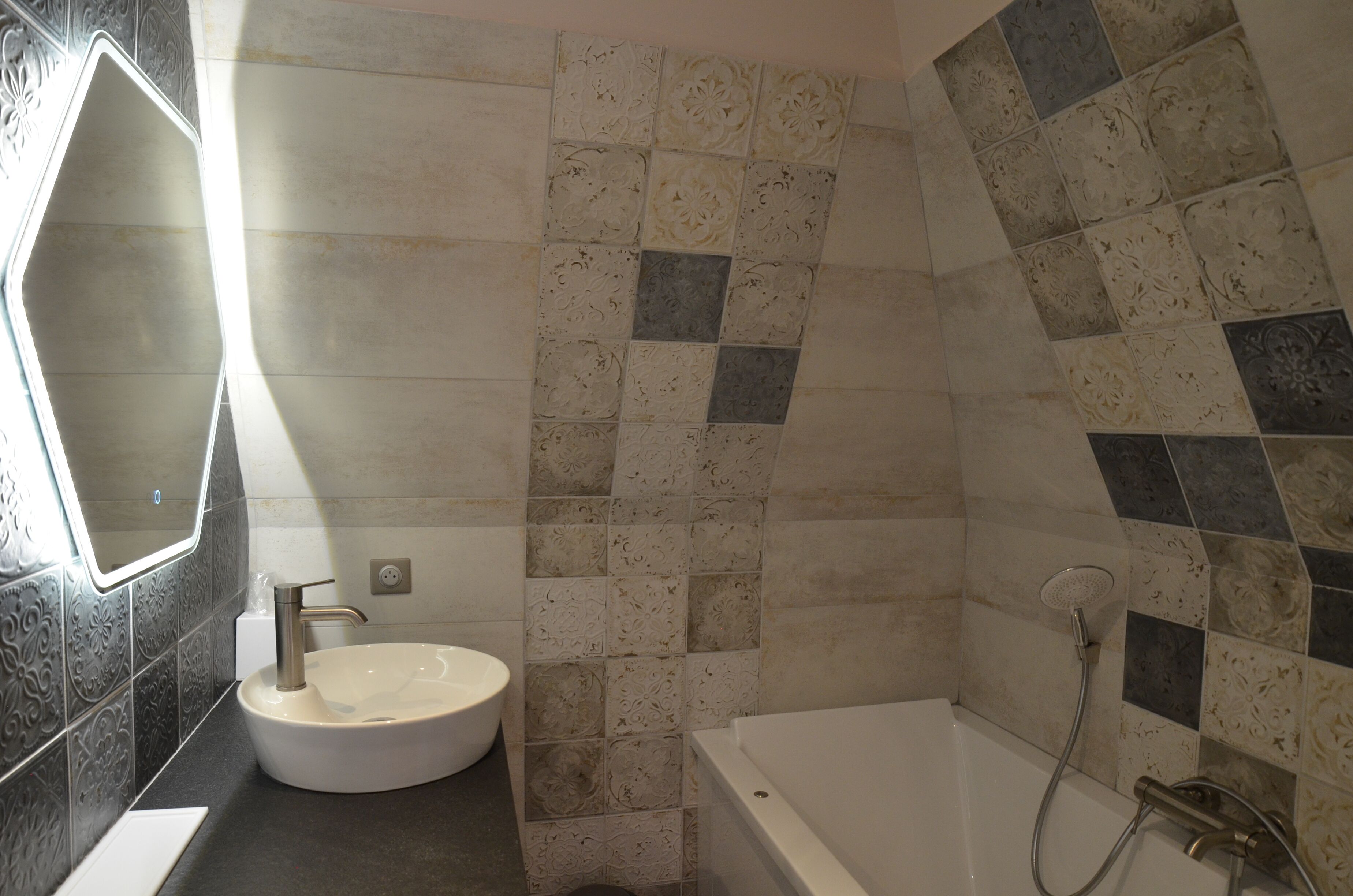 Un baño con un lavamanos blanco, un espejo y una zona de ducha.