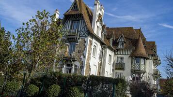 Un grand bâtiment historique à plusieurs étages, doté de toits à pignons saillants et présentant un mélange de styles architecturaux.