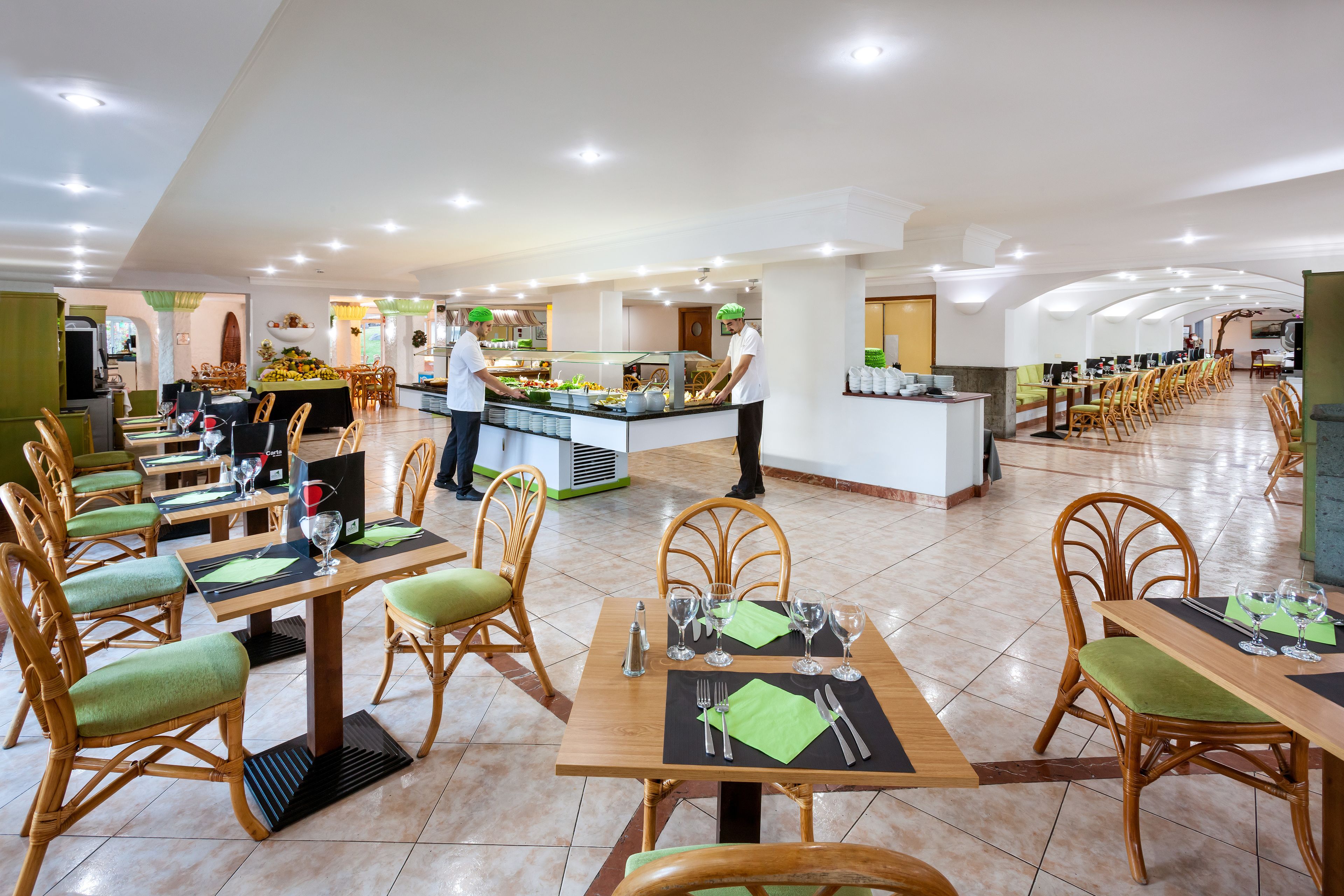 Ein geräumiger Speisebereich mit mehreren Tischen, Stühlen, einer Buffet-Theke und einer sauberen, hellen Atmosphäre.