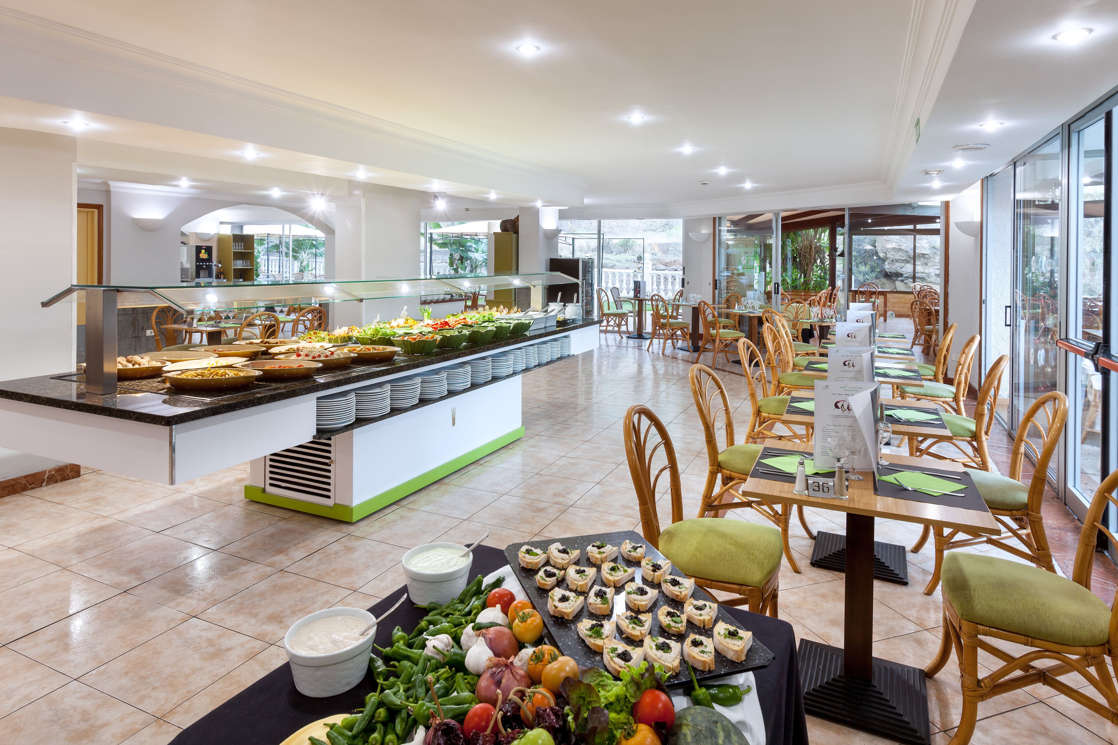 A buffet area with a variety of food items and a seating area with tables and chairs.