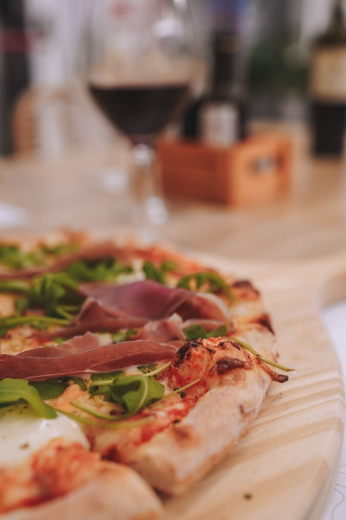 A pizza with toppings on a wooden board.