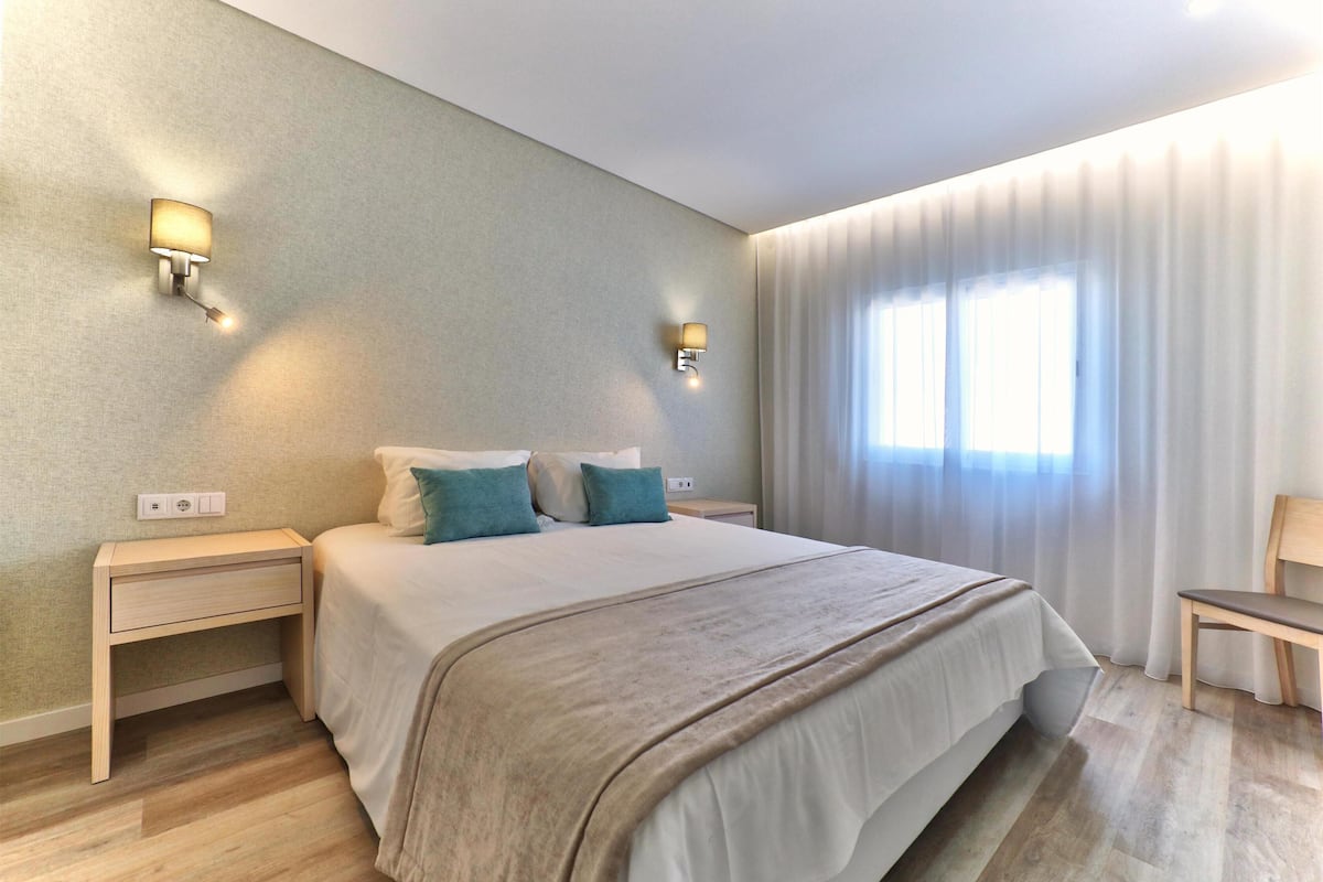 Tabla de planchar con plancha y ropa de cama
