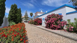 A cobblestone pathway leading to a building with blue trim and white walls. - Agua Hotels Vila Branca (Lagos)