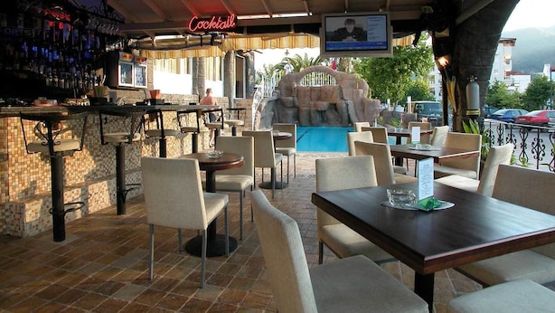 An outdoor bar area with a pool, seating, and a bar counter. - Hotel Devamlı (Marmaris)