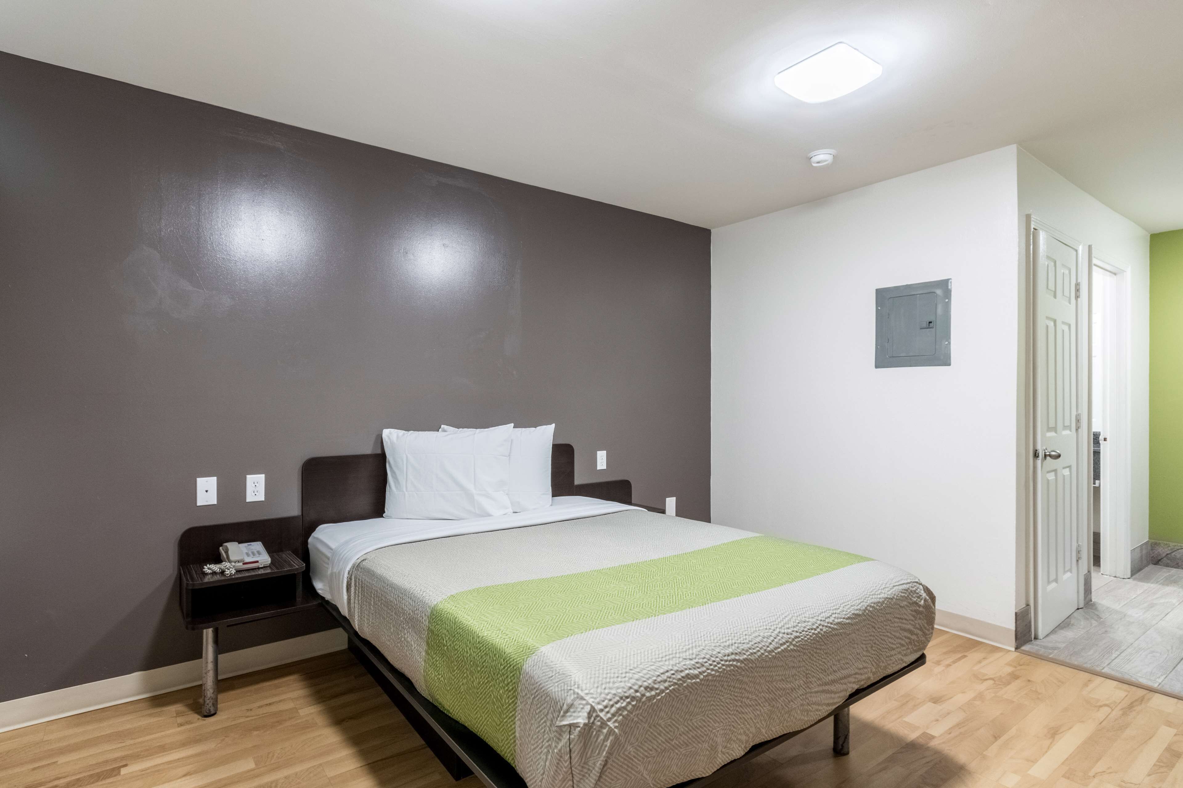 Un dormitorio con cama, mesita de noche y mesilla.