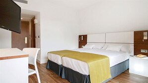A hotel room with a bed, a desk, and a television. - Hotel Globales Cala Blanca (Ciutadella de Menorca)
