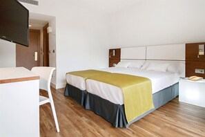 A hotel room with a bed, a desk, and a television. - Hotel Globales Cala Blanca (Ciutadella de Menorca)