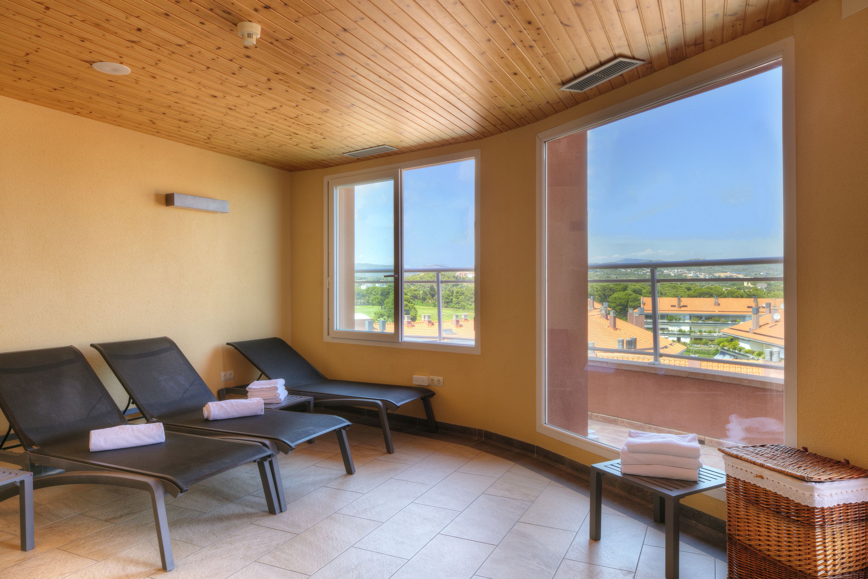 Una habitación con dos sillones reclinables, una mesita y una cesta de mimbre.