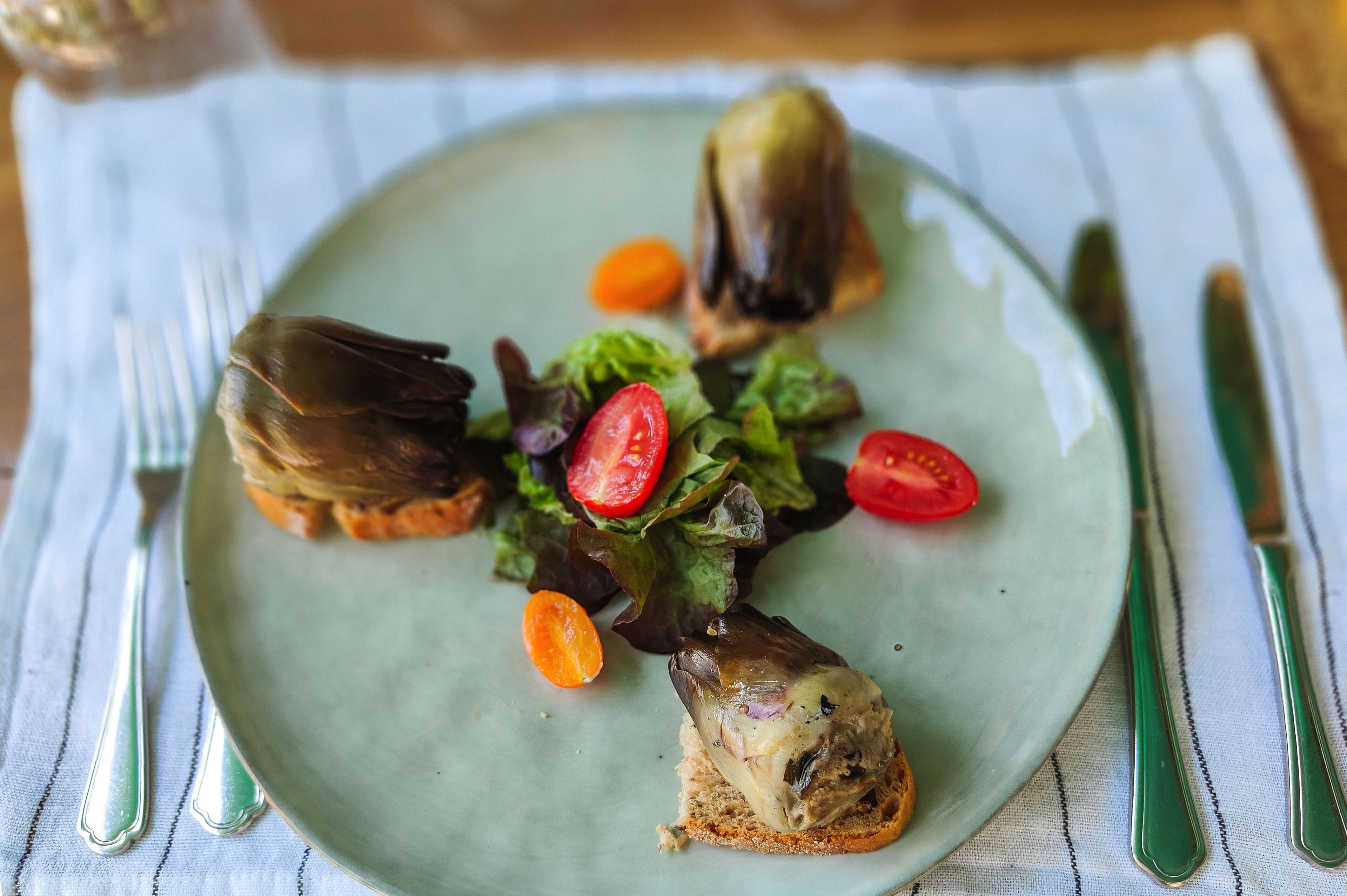 A plate with a sandwich, salad, and a slice of bread.