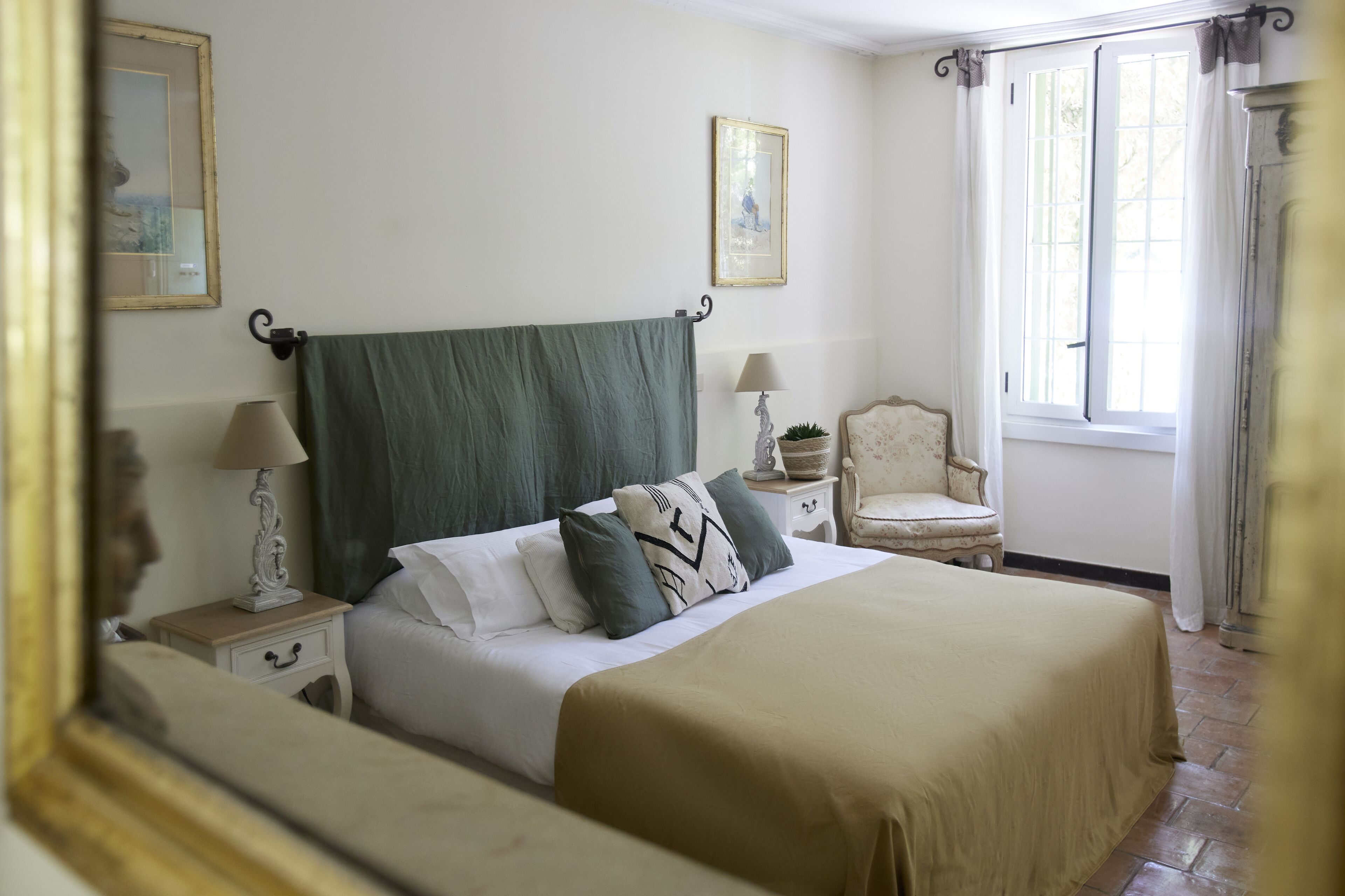 Une chambre à coucher bien rangée, avec un lit, des tables de chevet, une chaise et une fenêtre.