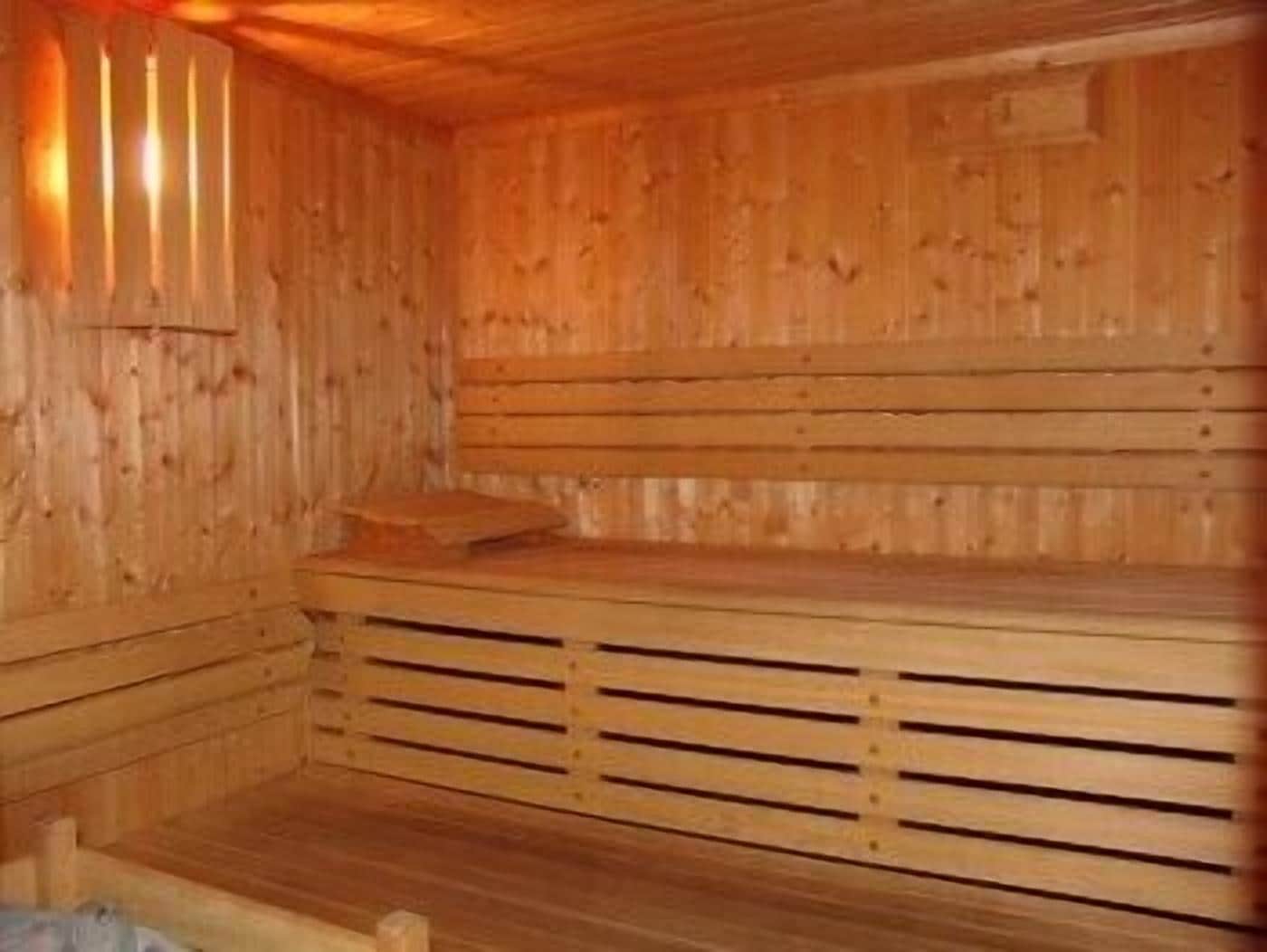 Een houten sauna met banken en een lamelvloer.