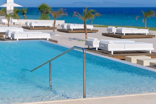 A pool area with lounge chairs and a view of the ocean. - Sun Beach Resort (Rhodes)