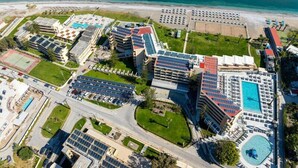 Un complexe hôtelier comprenant plusieurs bâtiments, des piscines et une plage.