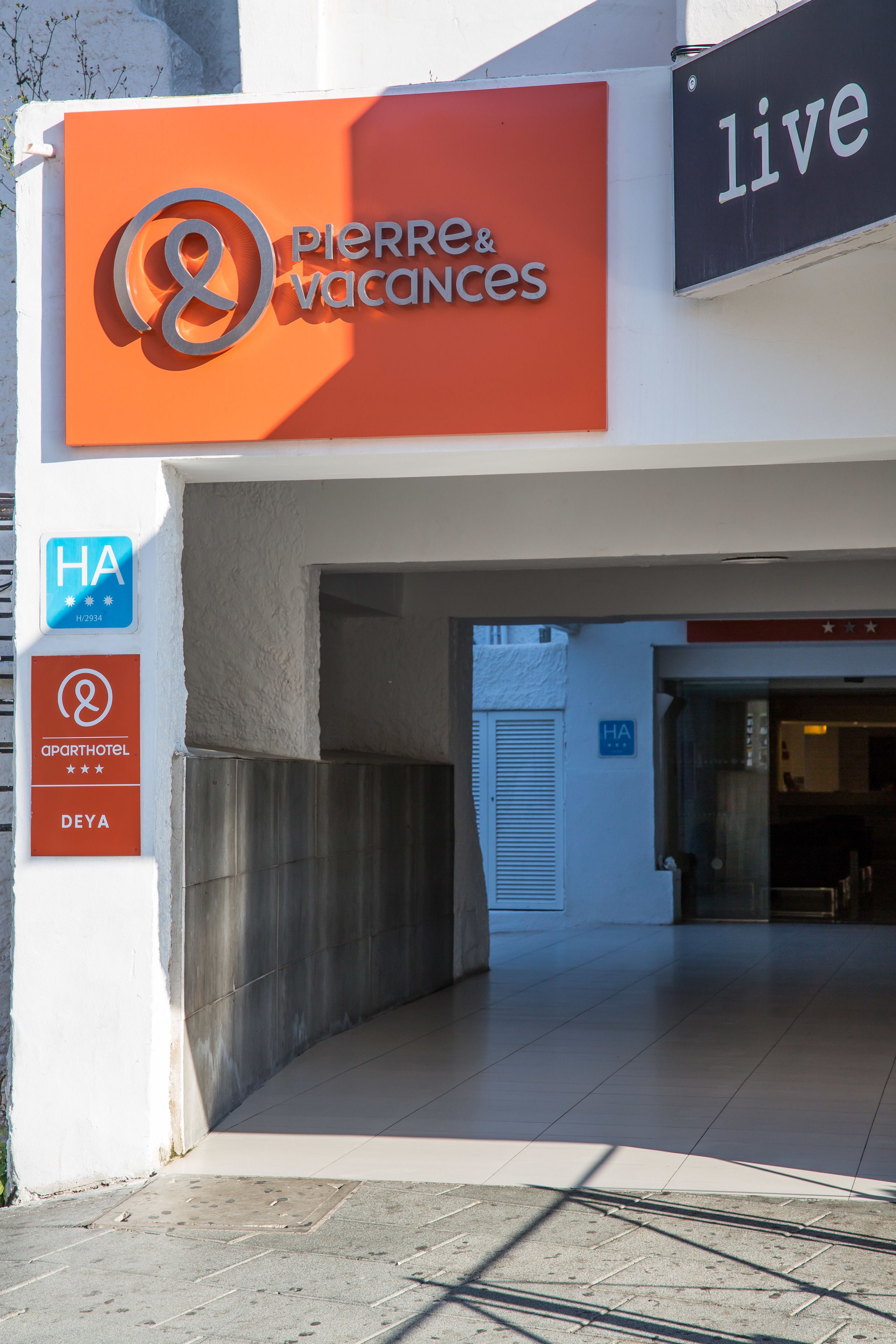 Entrada de hotel con señalización que indica 'Pierre & Vacances' y 'Live'.